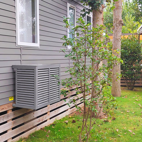 Cache climatiseur en bois naturel QUETZAL sur un mobil-home